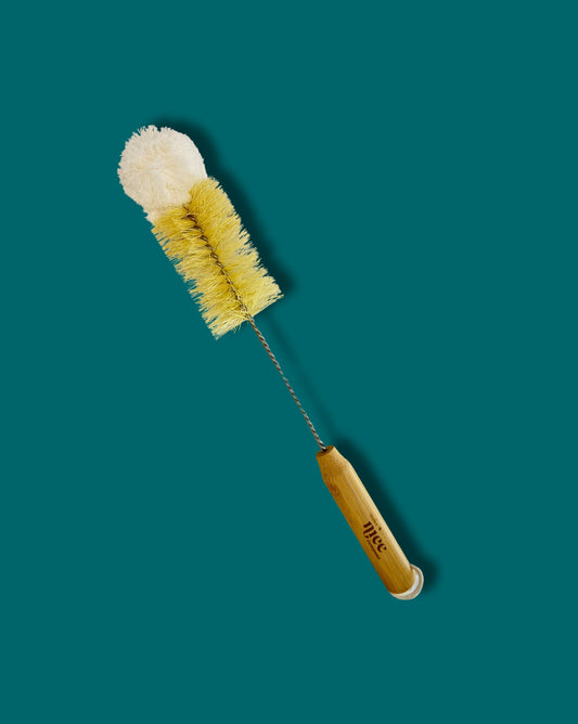 Cleaning brush with a wooden handle on a teal background